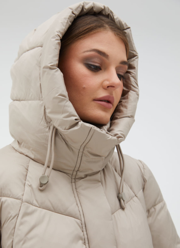 Женский пуховик бежевого цвета с капюшоном